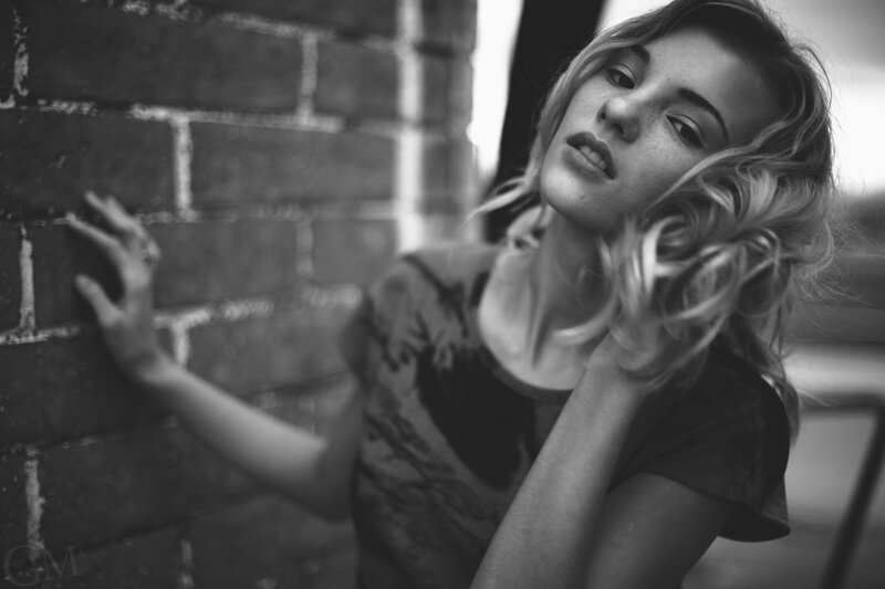woman leaning against brick wall