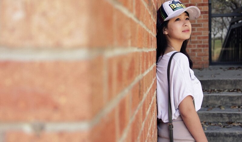 woman leaning against brick wall