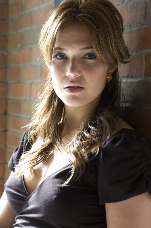 woman leaning against brick wall