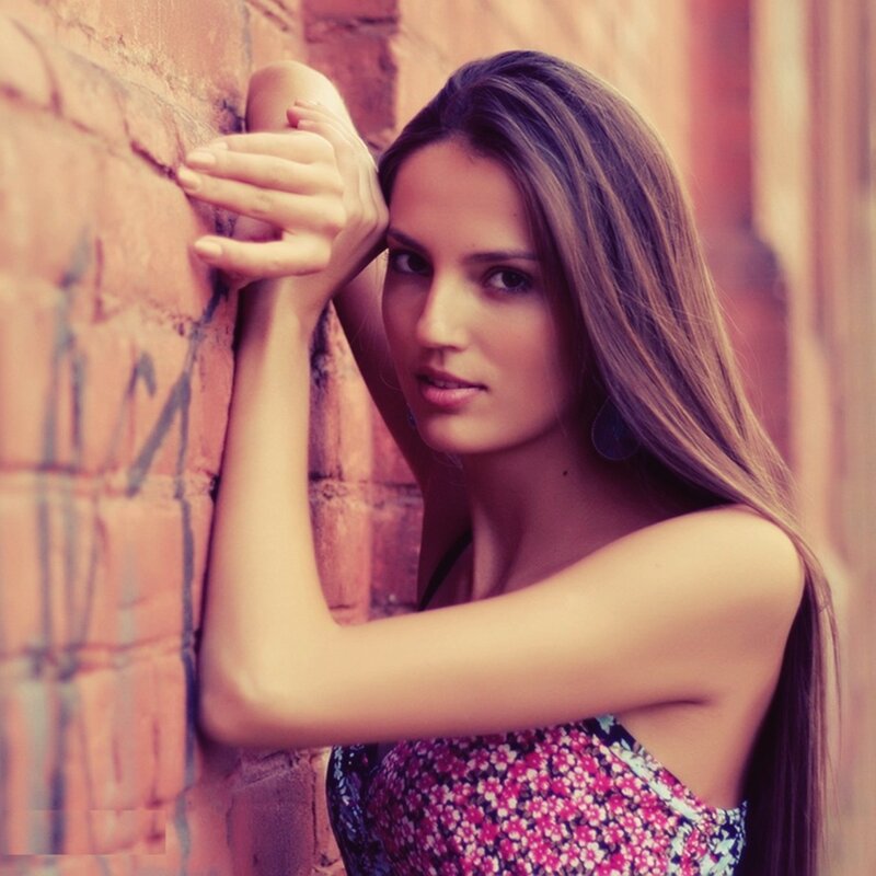 woman leaning against brick wall