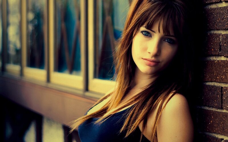 woman leaning against brick wall