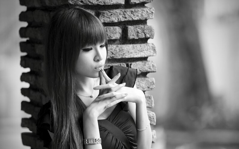 woman leaning against brick wall