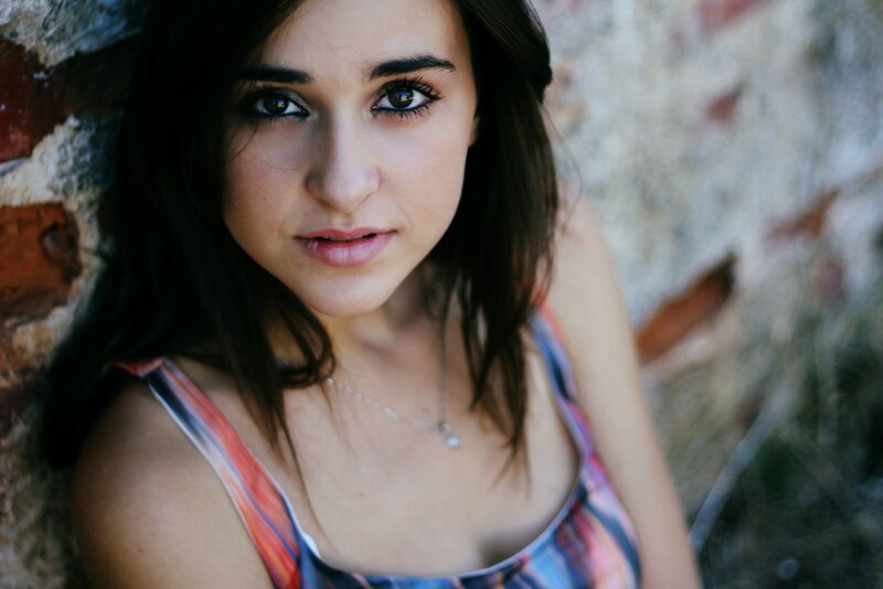 woman leaning against brick wall