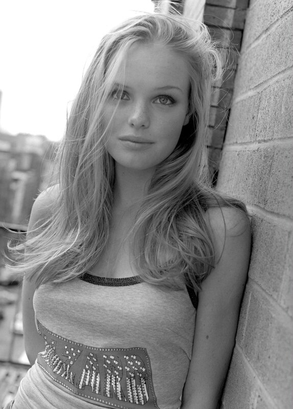 woman leaning against brick wall