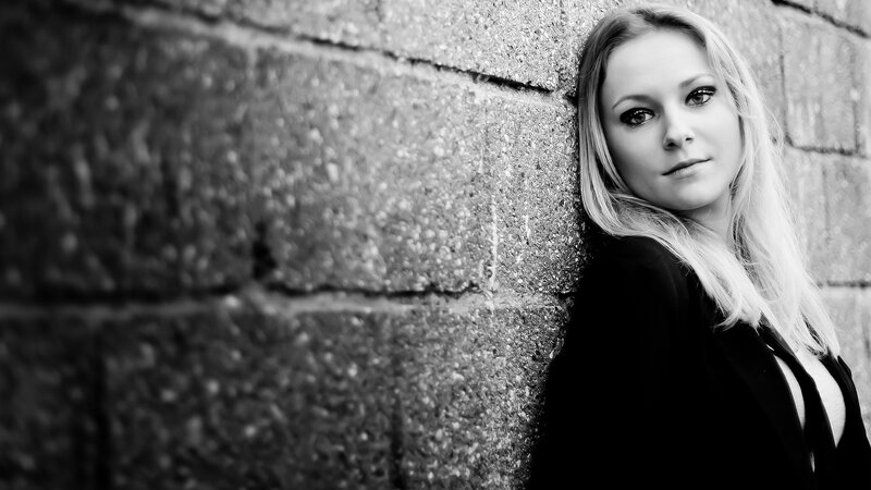 woman leaning against brick wall