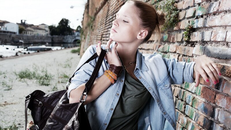 woman leaning against brick wall
