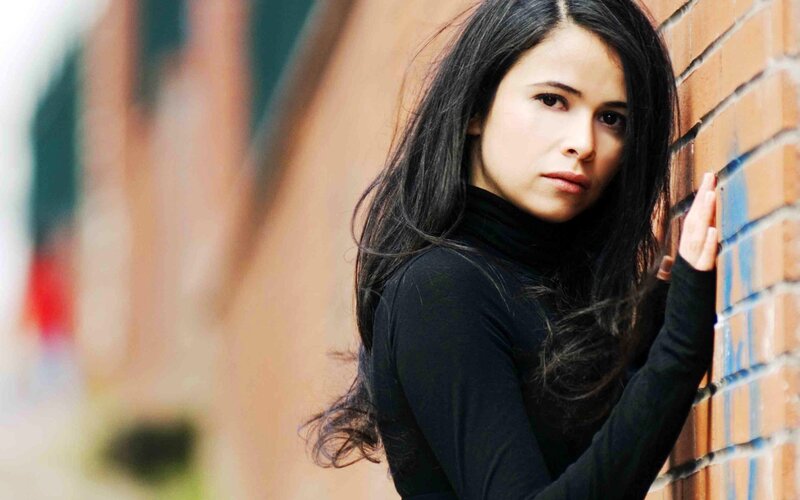 woman leaning against brick wall