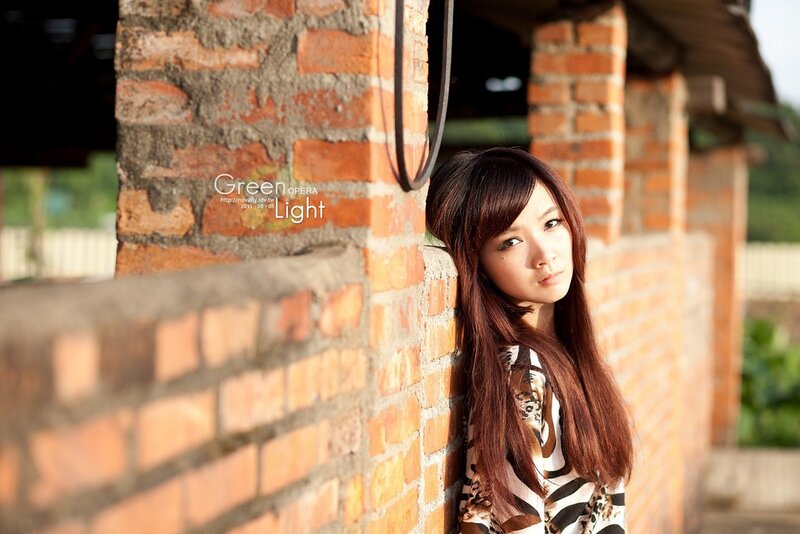 woman leaning against brick wall
