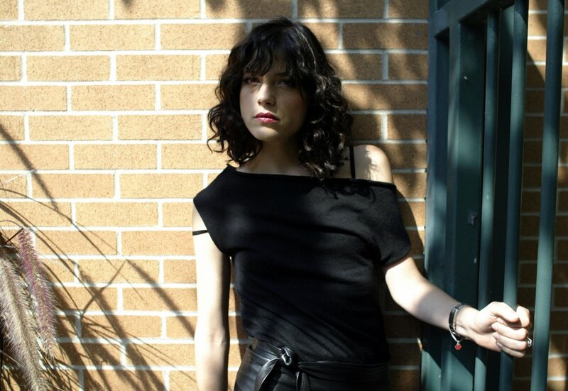 woman leaning against brick wall
