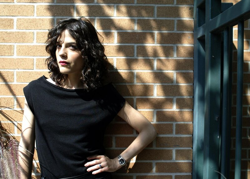 woman leaning against brick wall