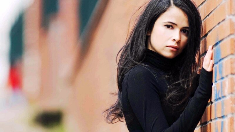 woman leaning against brick wall