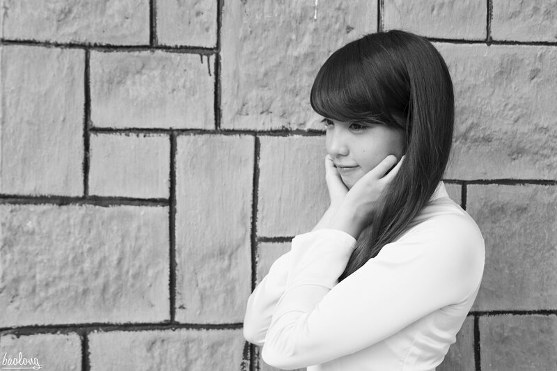 woman leaning against brick wall