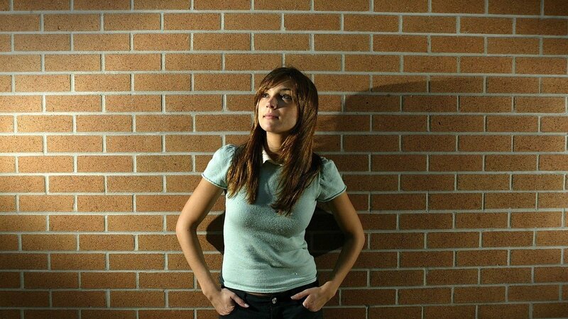 woman leaning against brick wall