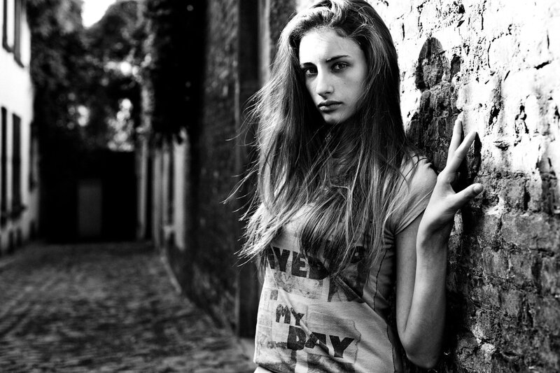 woman leaning against brick wall