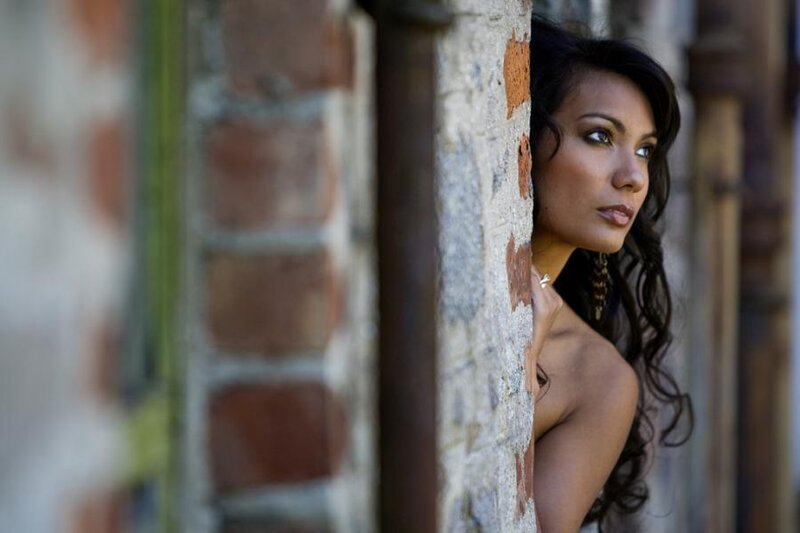 Woman Leaning Against Brick Wall — Brown
