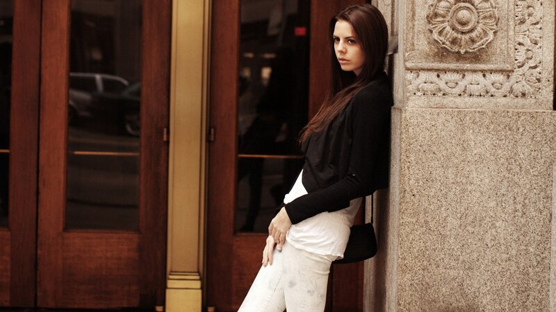 woman leaning against building