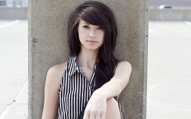 woman leaning against concrete pillar