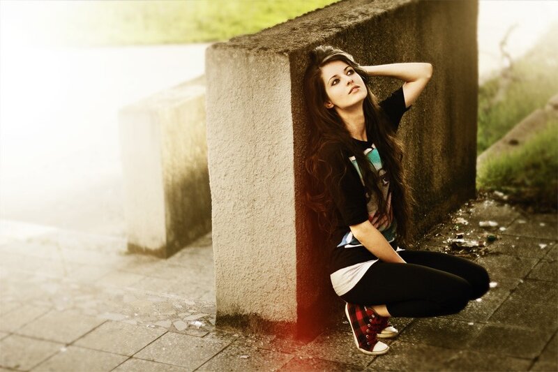 woman leaning against concrete wall