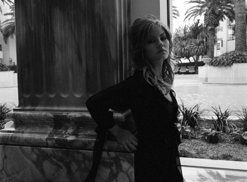 woman leaning against marble pillar
