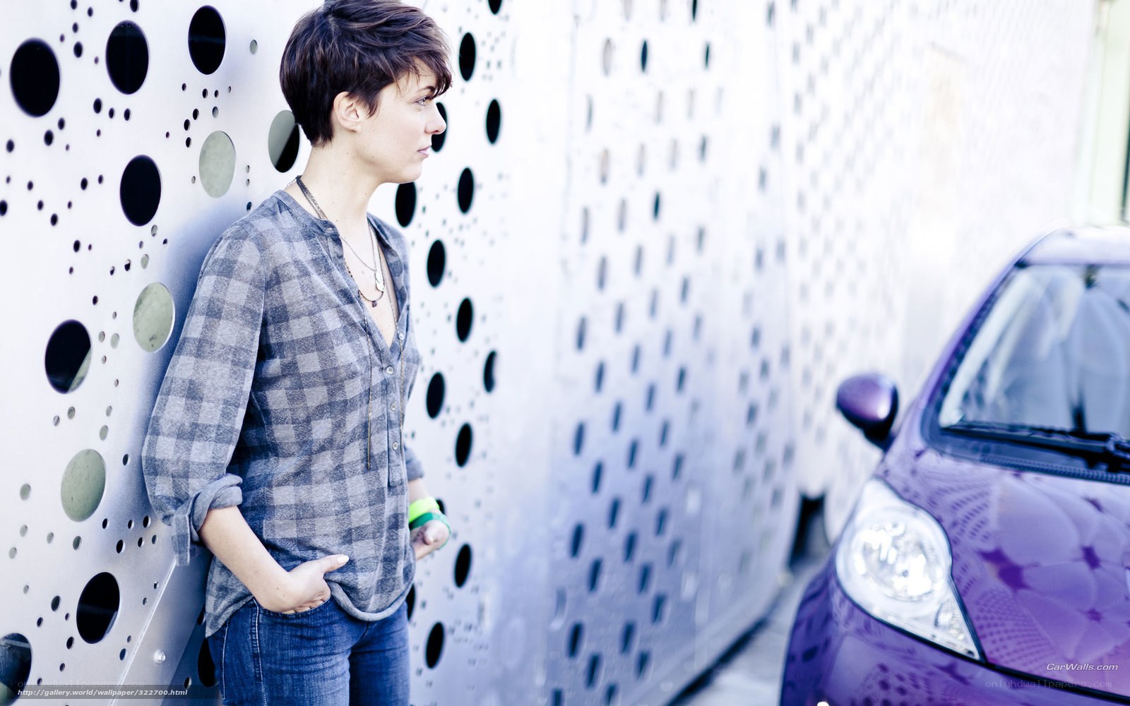woman leaning against perforated wall