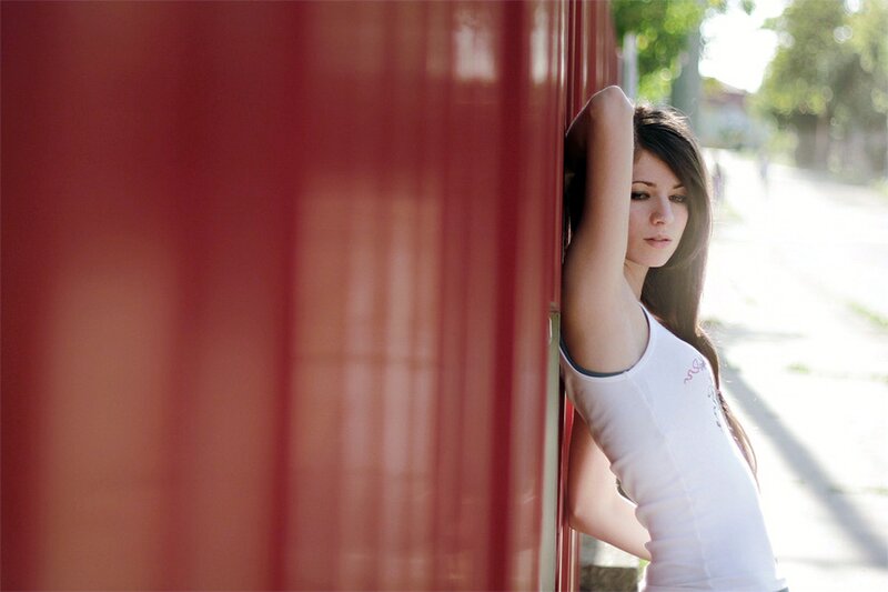 woman leaning against red wall