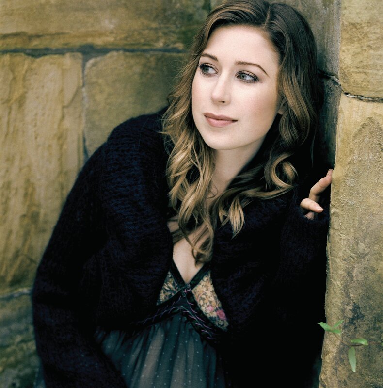 woman leaning against stone wall