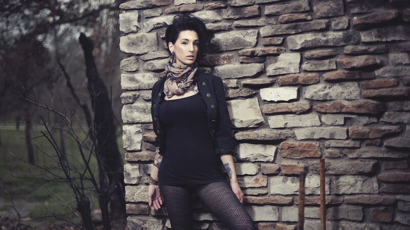 woman leaning against stone wall