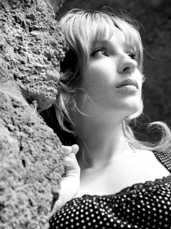 woman leaning against stone wall