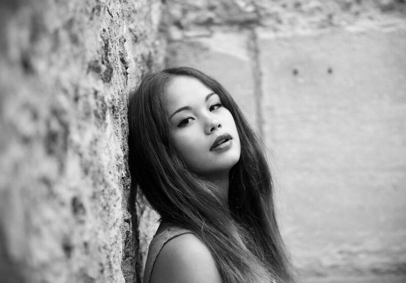 woman leaning against stone wall