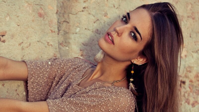 woman leaning against stone wall