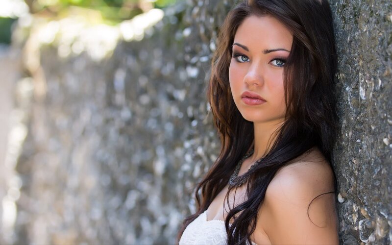 woman leaning against stone wall