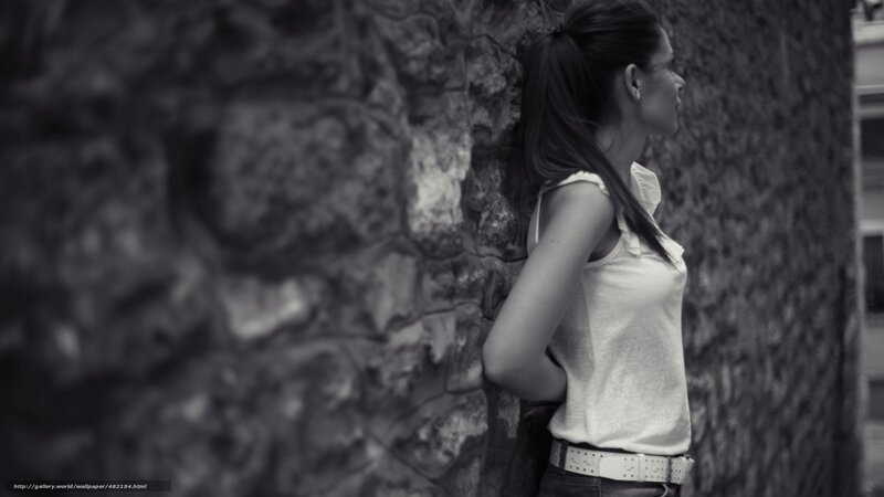 woman leaning against stone wall