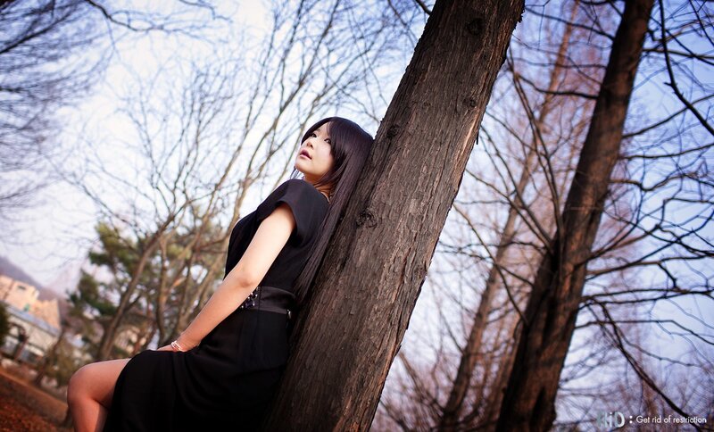 woman leaning against tree