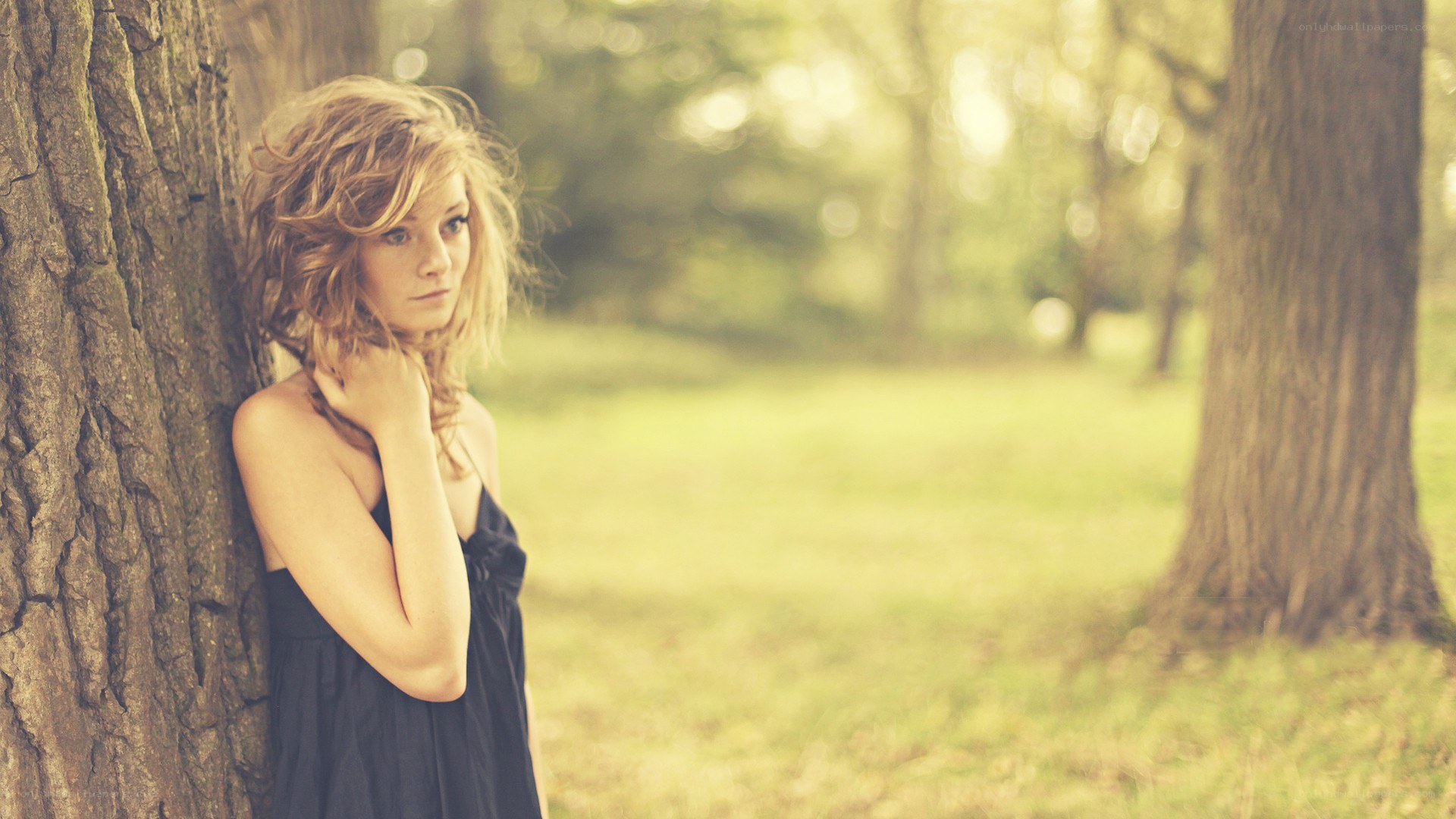 woman leaning against tree