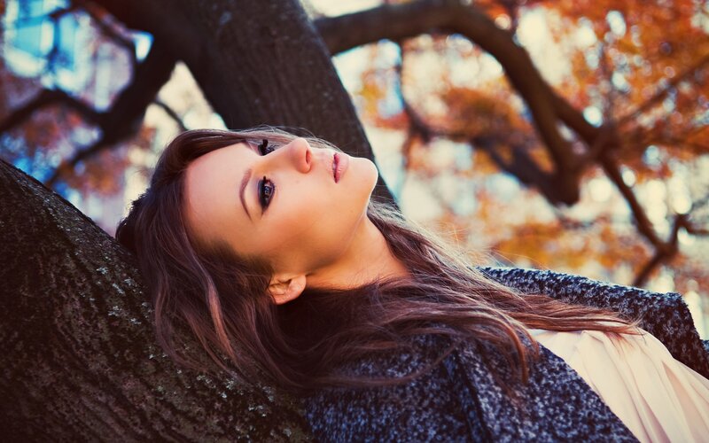 woman leaning against tree