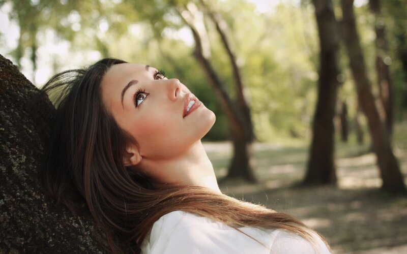 woman leaning against tree