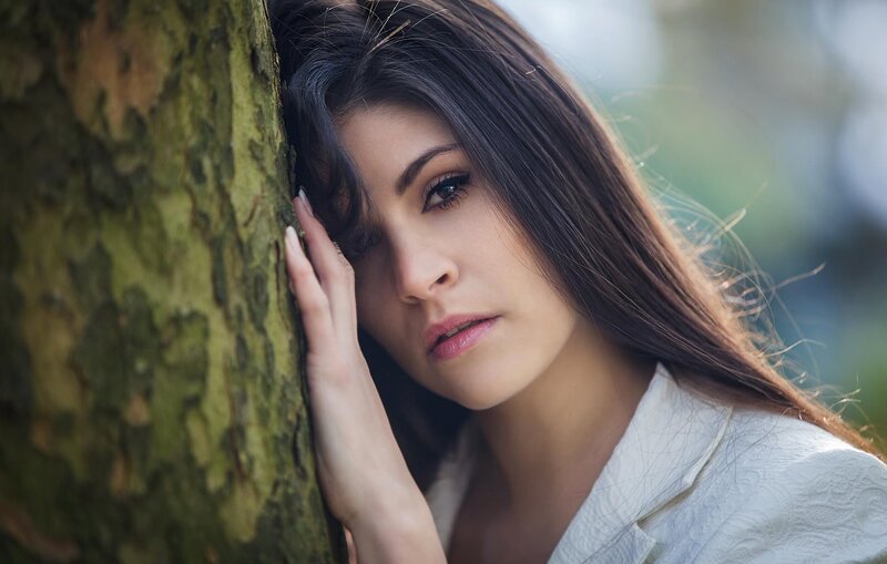 woman leaning against tree