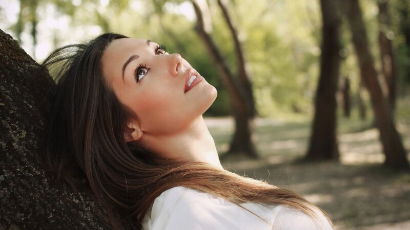 woman leaning against tree