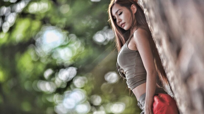 woman leaning against tree