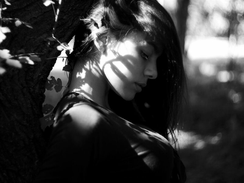 Woman Leaning Against Tree — Black, Dramatic, Afternoon