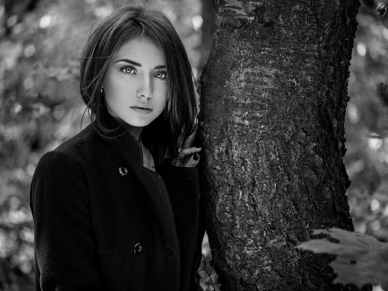 Woman Leaning Against Tree — Black, Serious