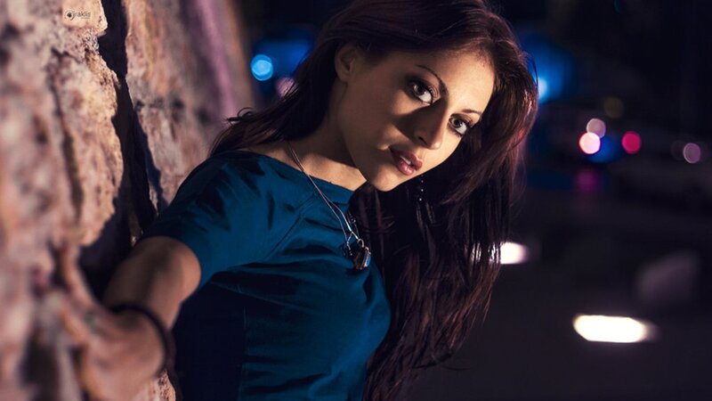 woman leaning against wall at night