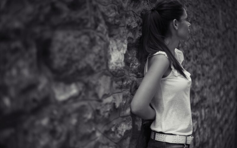 Woman Leaning Against Wall — Black, Contemplative