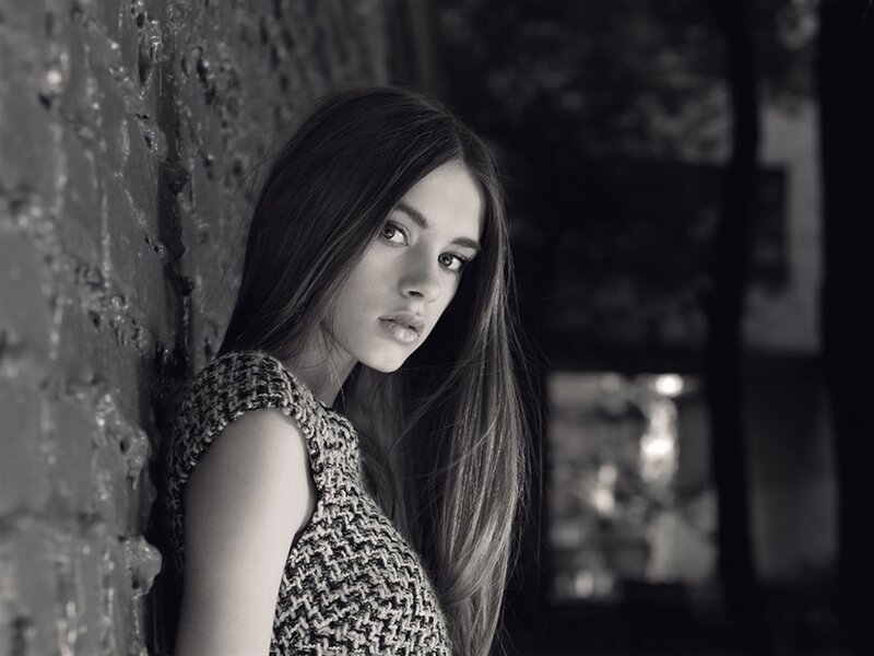 Woman Leaning Against Wall — Black, Dramatic, Photograph, Long Hair