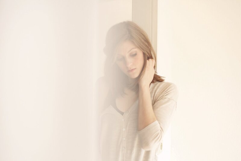 Woman Leaning Against Wall — White, Serene