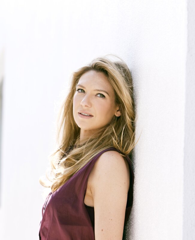 woman leaning against white wall