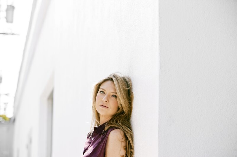 woman leaning against white wall