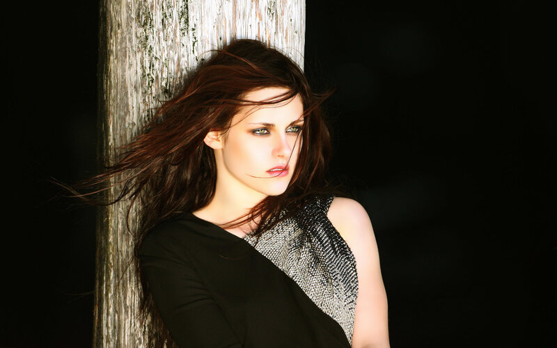 woman leaning against wooden post