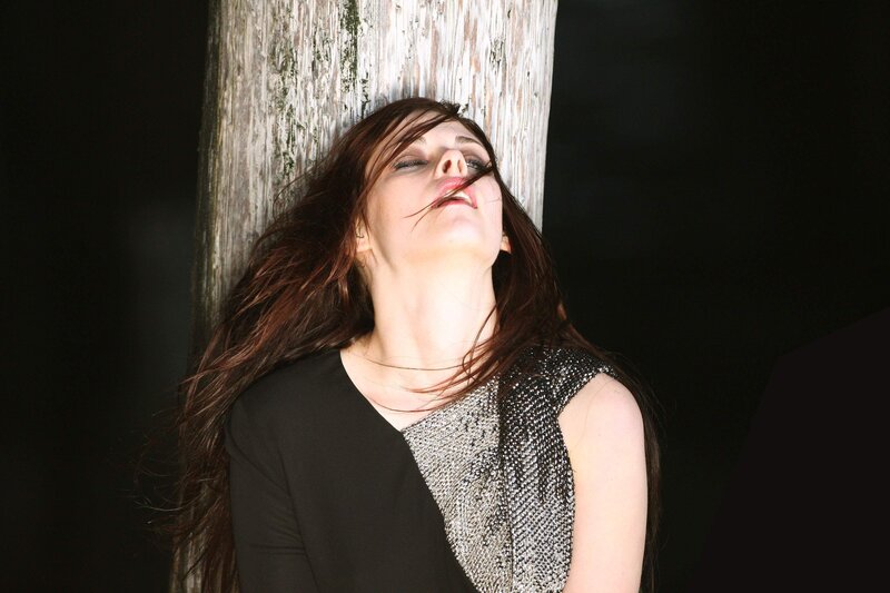 woman leaning against wooden post