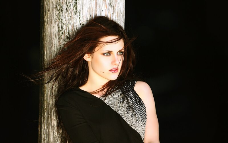 woman leaning against wooden post
